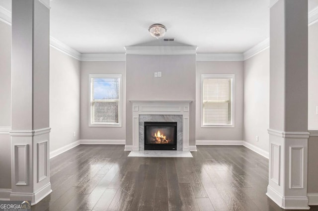 unfurnished living room with decorative columns, visible vents, dark wood-style floors, crown molding, and a fireplace