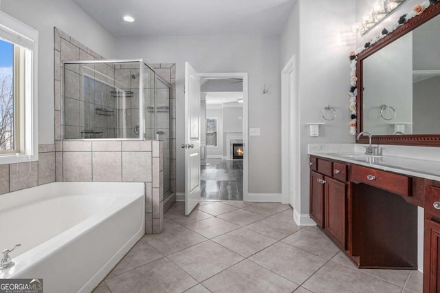 bathroom with tile patterned flooring, a shower stall, a bath, and a glass covered fireplace