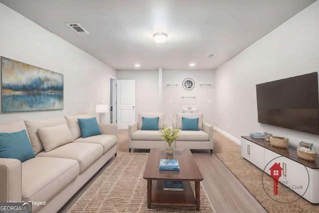 living area featuring baseboards, visible vents, wood finished floors, and recessed lighting