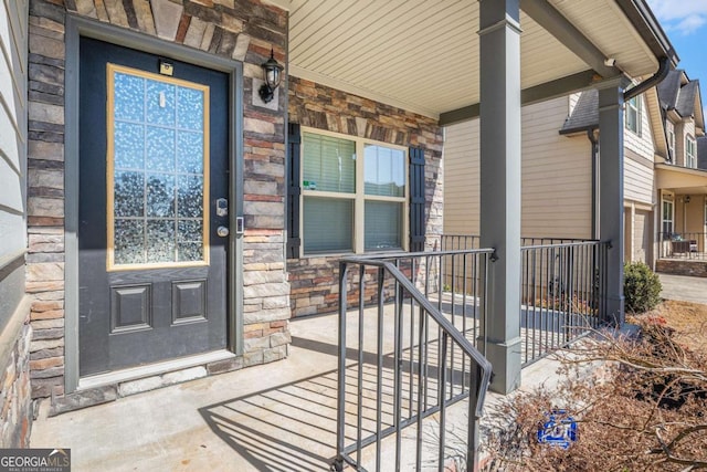 doorway to property with covered porch and stone siding