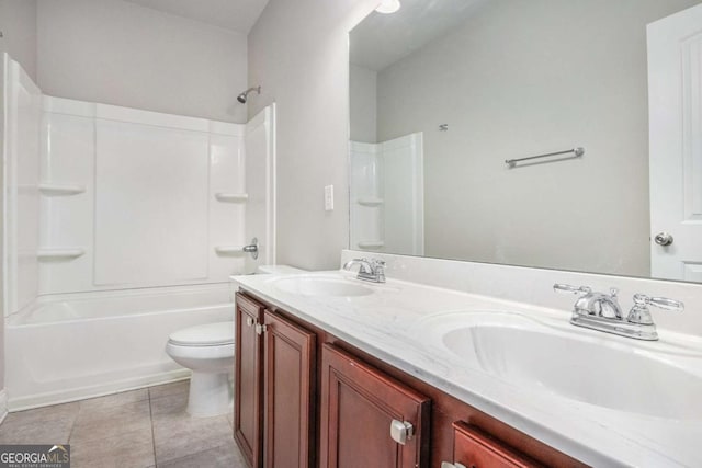 full bath featuring toilet, double vanity, a sink, and tile patterned floors