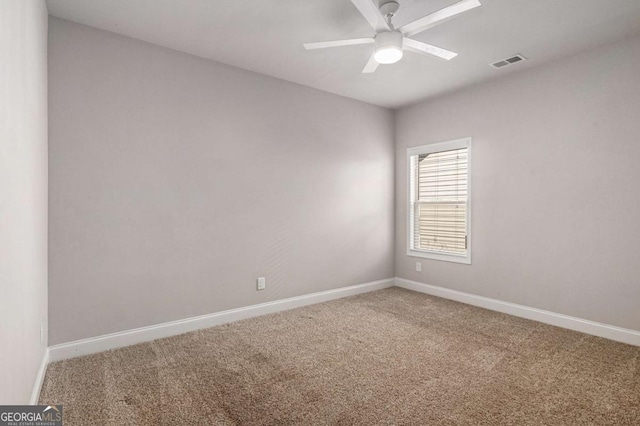 carpeted empty room featuring baseboards, visible vents, and a ceiling fan