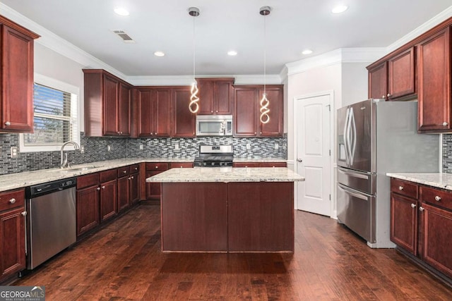 kitchen with a center island, dark wood finished floors, stainless steel appliances, visible vents, and a sink