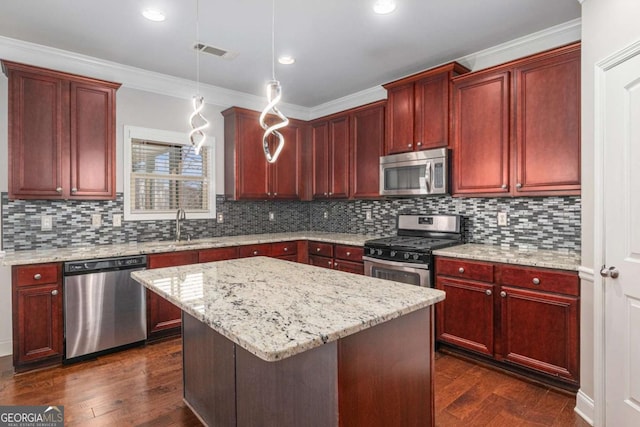 kitchen with dark brown cabinets, appliances with stainless steel finishes, and a sink