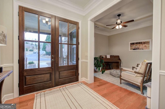 foyer featuring french doors, ornamental molding, ceiling fan, wood finished floors, and baseboards