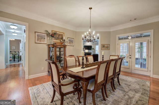 dining room featuring ornamental molding, french doors, and light wood finished floors