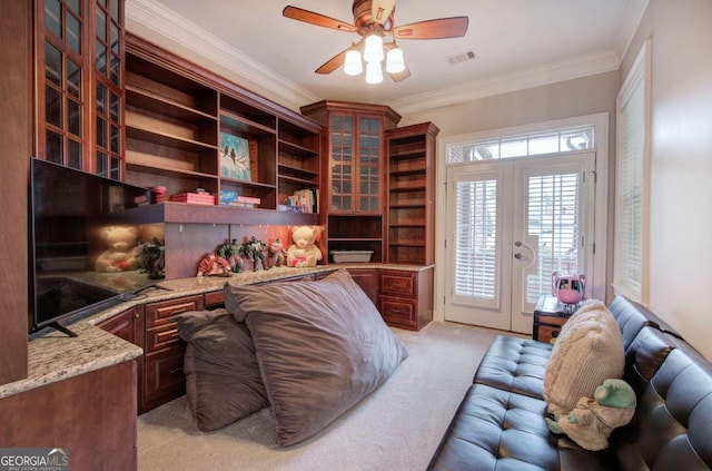 home office featuring ceiling fan, light carpet, visible vents, ornamental molding, and built in study area