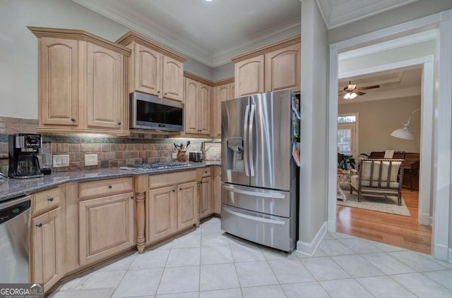 kitchen featuring stainless steel appliances, crown molding, light brown cabinets, backsplash, and light tile patterned flooring