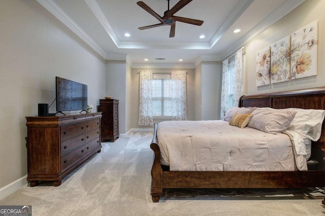 carpeted bedroom with ornamental molding, a tray ceiling, and baseboards