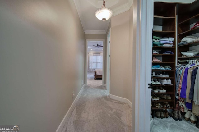 corridor with carpet floors, baseboards, and ornamental molding