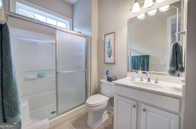 full bathroom with a stall shower, vanity, toilet, and tile patterned floors