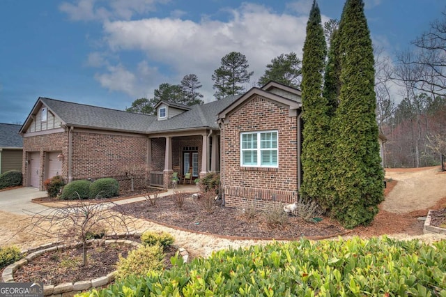 view of front of home featuring an attached garage, driveway, french doors, and brick siding