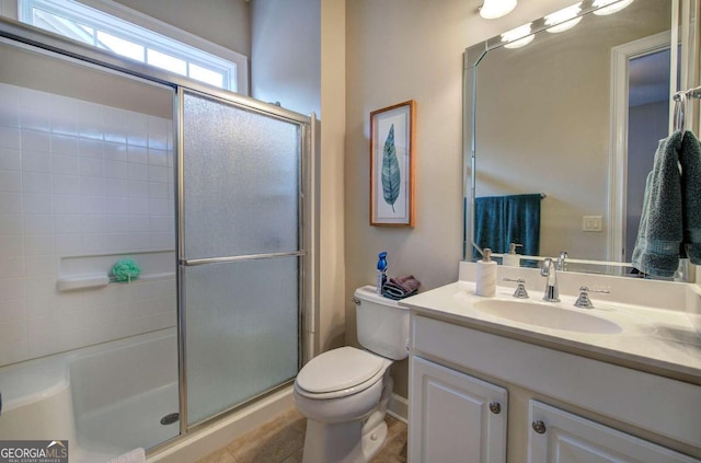 full bath featuring a shower with door, vanity, and toilet