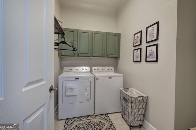 clothes washing area featuring cabinet space, baseboards, washer and clothes dryer, and light tile patterned flooring