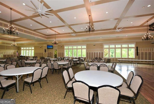 dining area featuring a chandelier, coffered ceiling, crown molding, and wood finished floors