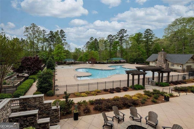 community pool with a patio area, fence, and a pergola