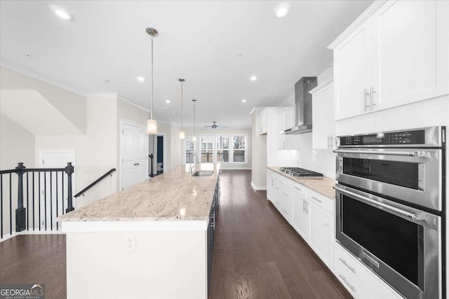 kitchen with gas stovetop, wall chimney exhaust hood, white cabinetry, and double oven