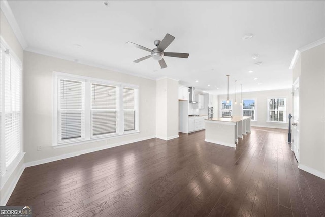 unfurnished living room featuring recessed lighting, dark wood-style flooring, a ceiling fan, baseboards, and ornamental molding