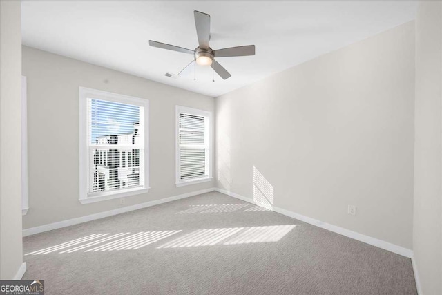 unfurnished room with a ceiling fan, carpet flooring, visible vents, and baseboards