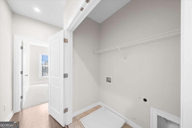 laundry area with hookup for an electric dryer, laundry area, washer hookup, wood finished floors, and baseboards