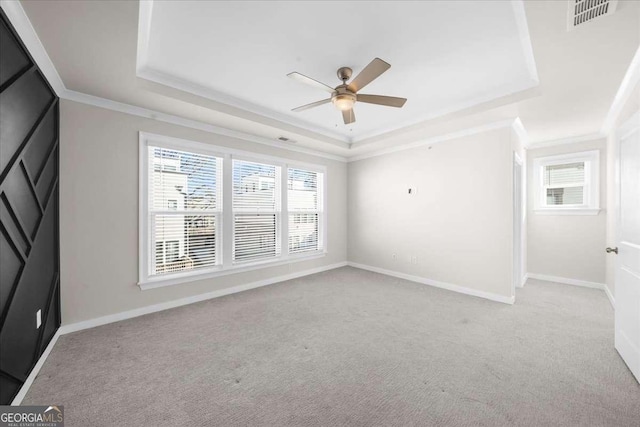 unfurnished room featuring visible vents, a raised ceiling, and a wealth of natural light