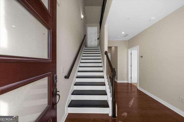 stairs with wood finished floors and baseboards