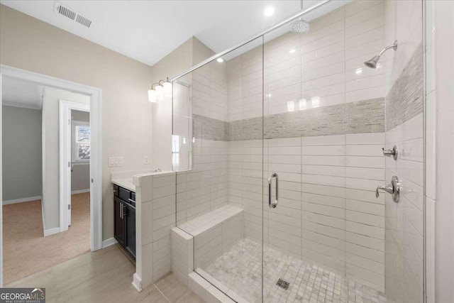 full bathroom featuring a stall shower, baseboards, visible vents, and vanity