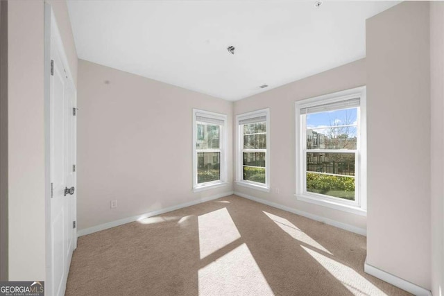 carpeted empty room featuring baseboards