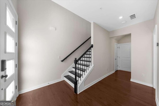 foyer entrance with stairs, visible vents, baseboards, and wood finished floors