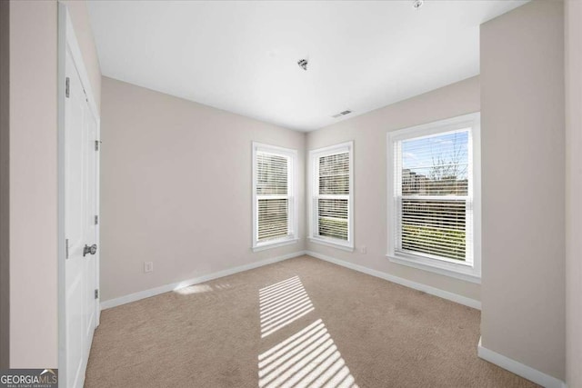 carpeted empty room with visible vents and baseboards