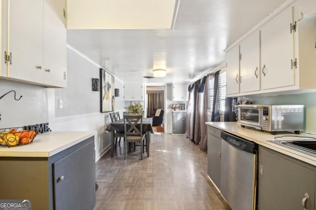 kitchen with white cabinets, ornamental molding, stainless steel appliances, light countertops, and a sink