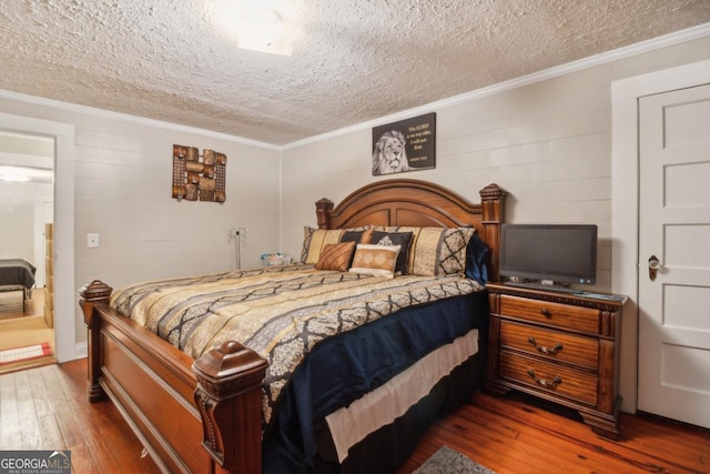 bedroom with ornamental molding, a textured ceiling, and hardwood / wood-style floors