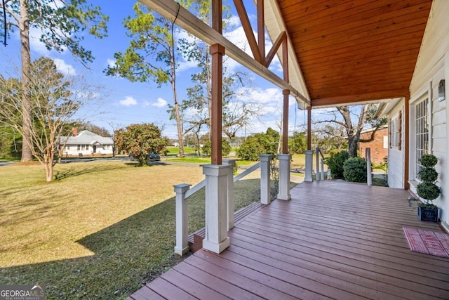 wooden deck featuring covered porch and a lawn