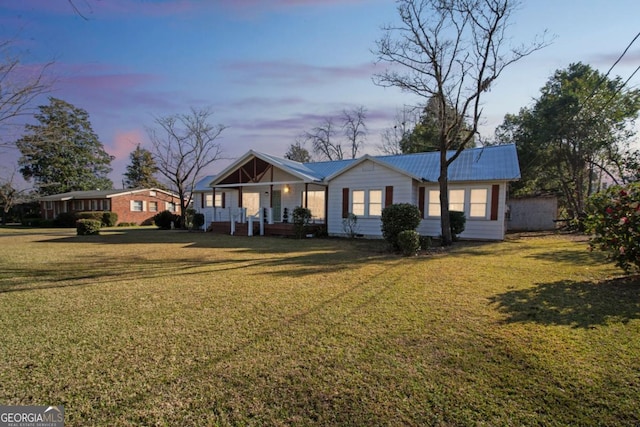 view of front of property with crawl space, metal roof, and a front yard