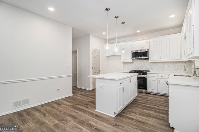 kitchen featuring appliances with stainless steel finishes, dark wood-type flooring, a sink, and visible vents