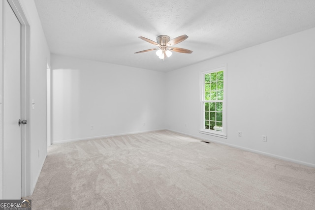 unfurnished room with baseboards, visible vents, a ceiling fan, a textured ceiling, and carpet floors