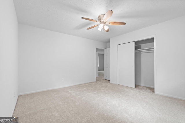 unfurnished bedroom featuring a ceiling fan, carpet, a closet, and a textured ceiling