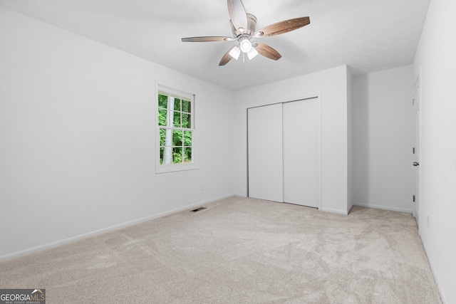 unfurnished bedroom featuring visible vents, baseboards, a ceiling fan, a closet, and carpet