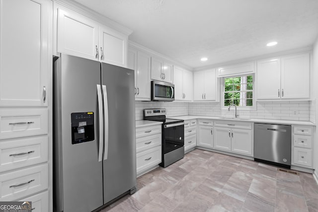 kitchen featuring stainless steel appliances, light countertops, and white cabinetry