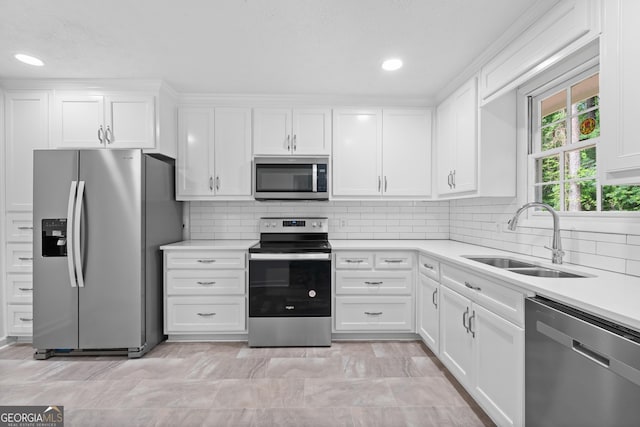 kitchen featuring a sink, white cabinets, light countertops, appliances with stainless steel finishes, and decorative backsplash