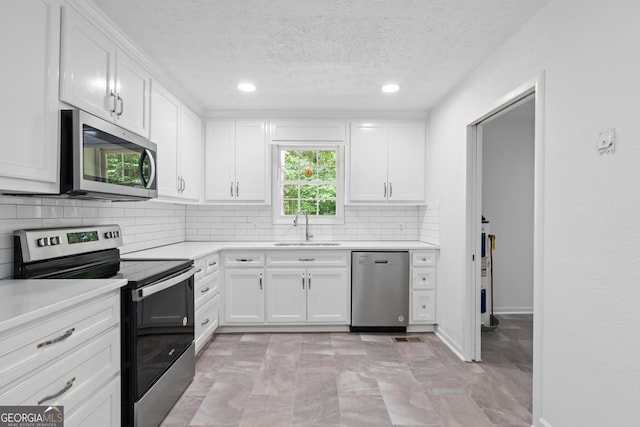 kitchen featuring tasteful backsplash, stainless steel appliances, a sink, and light countertops