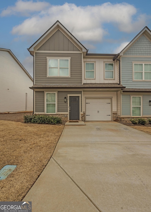 view of front of property with a garage, driveway, board and batten siding, and stone siding