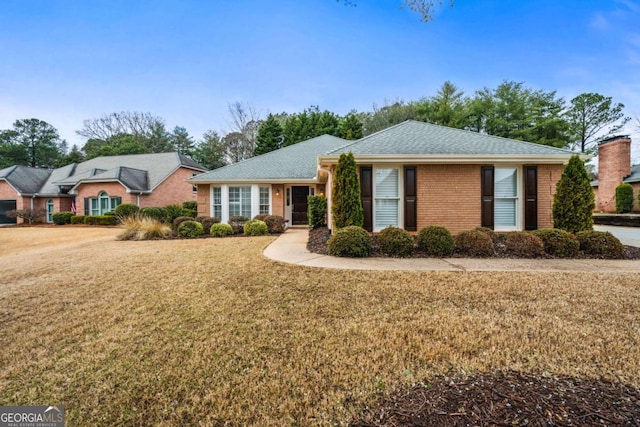 ranch-style home featuring brick siding and a front yard