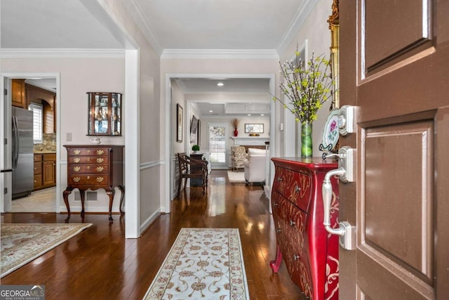 foyer featuring light wood-style flooring, baseboards, and crown molding