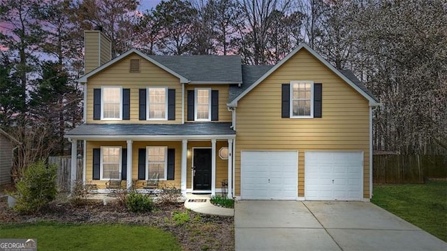 traditional-style house featuring a chimney, covered porch, concrete driveway, an attached garage, and fence