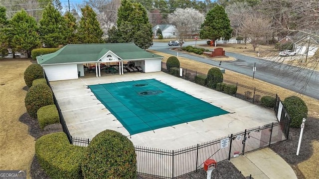 pool with a patio area and fence