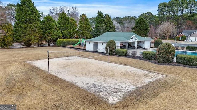 view of property's community with volleyball court, playground community, and fence