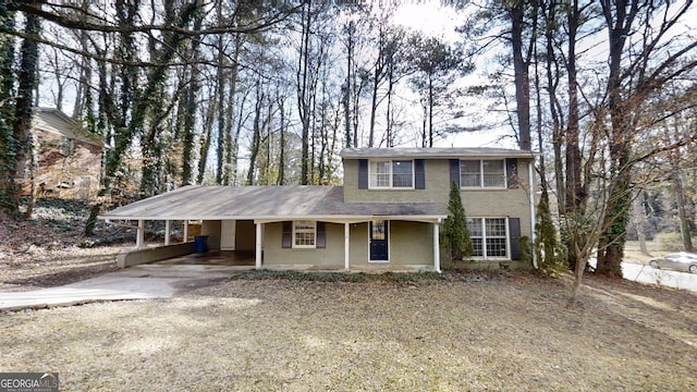 view of front facade with a carport, driveway, and stucco siding