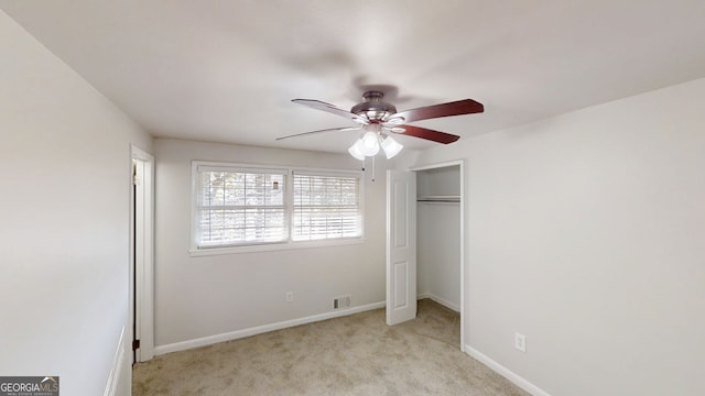 unfurnished bedroom featuring light carpet, visible vents, baseboards, and ceiling fan