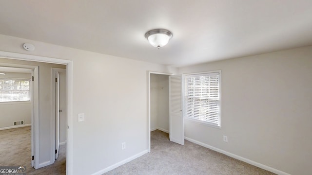 unfurnished bedroom featuring carpet floors, baseboards, visible vents, and a closet
